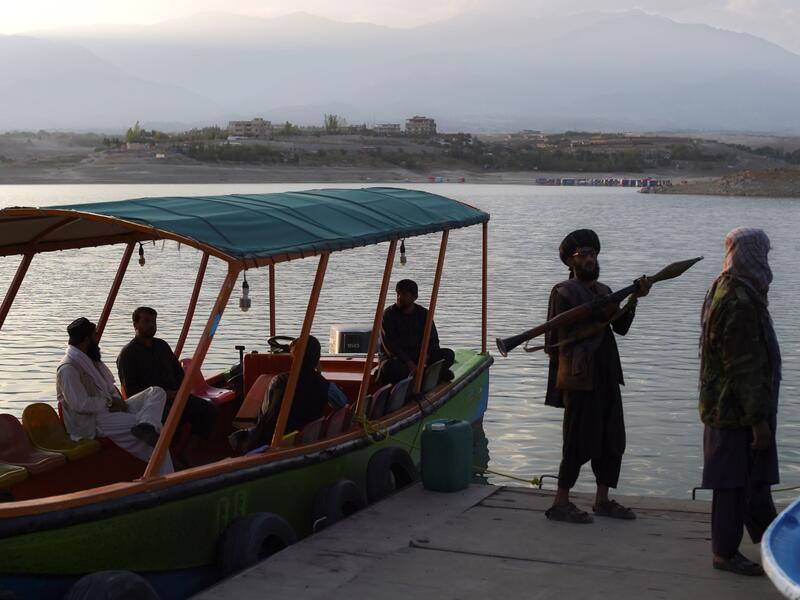 Taliban fighter shouts on the pirate ship ride at a fairground in western Kabul, as his armed comrades cackle and whoop on board the rickety attraction. (Photo by WAKIL KOHSAR / AFP) / TO GO WITH: AFGHANISTAN-CONFLICT-FAIRGROUND, SCENE BY JAMES EDGAR - TO GO WITH: Afghanistan-conflict-fairground, SCENE by James EDGAR