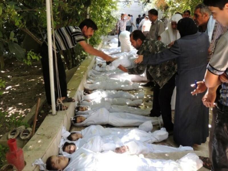 أطفال سوريا: تظهر مواطنين يحاولون التعرف على جثث القتلى من بينهم العديد من الأطفال أثناء نومهم، بعد هجوم بالغاز السام أطلقته قوات النظام. كان ذلك في 21 آب 2013.
