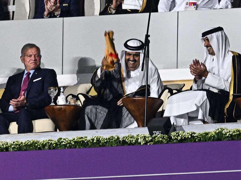 Qatar's former Emir Sheikh Hamad bin Khalifa al-Thani (2ndL) and Qatar's Emir Sheikh Tamim bin Hamad al-Thani waves a signed Qatari jersey next to Qatar's Emir Sheikh Tamim bin Hamad al-Thani (R) and Abdullah II King of Jordan (L) during the opening ceremony ahead of the Qatar 2022 World Cup 