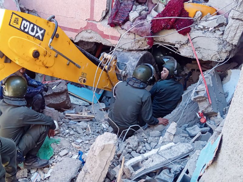 Rescue workers search for survivors in a collapsed house in Moulay Brahim, Al Haouz province, on September 9, 2023, after an earthquake