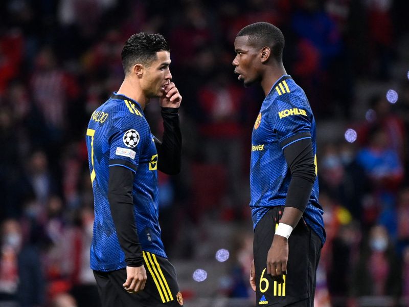 Manchester United's Portuguese forward Cristiano Ronaldo (L) speaks with Manchester United's French midfielder Paul Pogba before the start of the UEFA Champions League football match between Atletico de Madrid and Manchester United at the Wanda Metropolitano stadium in Madrid on February 23, 2022. (Photo by OSCAR DEL POZO / AFP)