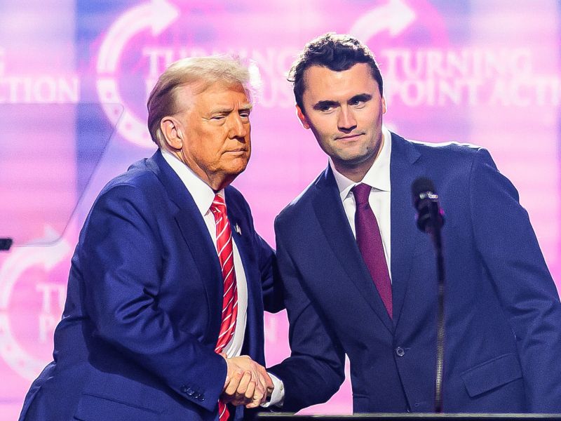 US right-wing activist Charlie Kirk (R) speaks on stage with President Donald Trump