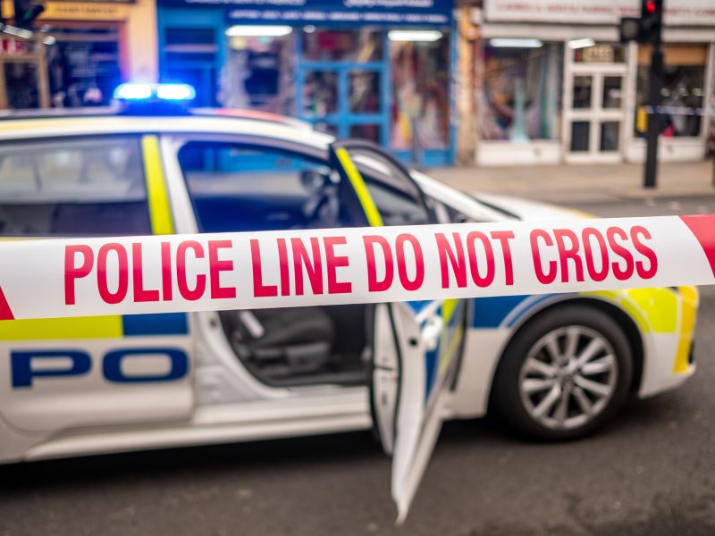 شريط الشرطة وسيارة شرطة في موقع جريمة خطيرة في لندن - المملكة المتحدة