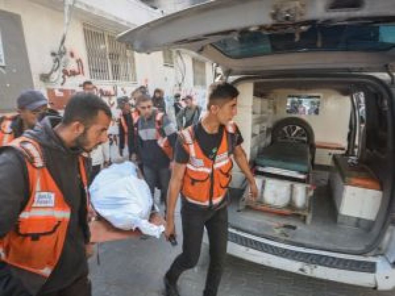  مسعفون وعاملو إغاثة ينقلون مصابًا أو جثمانًا إلى سيارة إسعاف أمام أحد المرافق الطبية في قطاع غزة