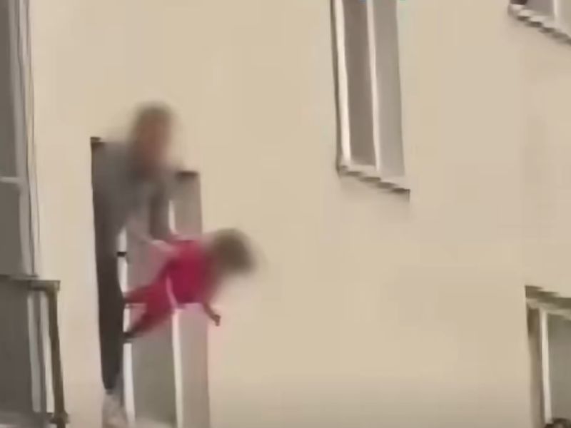 رجل يعلق ابنته البالغة من العمر ثلاث سنوات من النافذة كرهينة، ويُهددها بسكين 