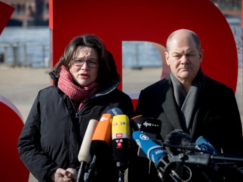 Andrea Nahles (L), parliamentary group leader of Germany's social democratic SPD party, and Hamburg's mayor and interim SPD leader Olaf Scholz stand in front of their party's logo as they give a statement, before counting starts of the ballots of their party members.
(Kay NIETFELD / DPA / AFP)