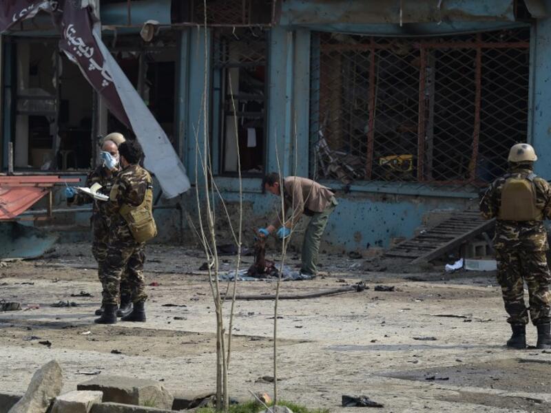 An Afghan investigator (C) inspect the remains of a body at the site where a suicide attacker blew himself up in a Shiite area of Kabul on Mar. 9, 2018. A suicide bomber on foot blew himself up in Kabul's Shiite area on Mar. 9, killing at least seven people, officials said, as militants dial up pressure on the war-weary Afghan capital.
(SHAH MARAI / AFP)