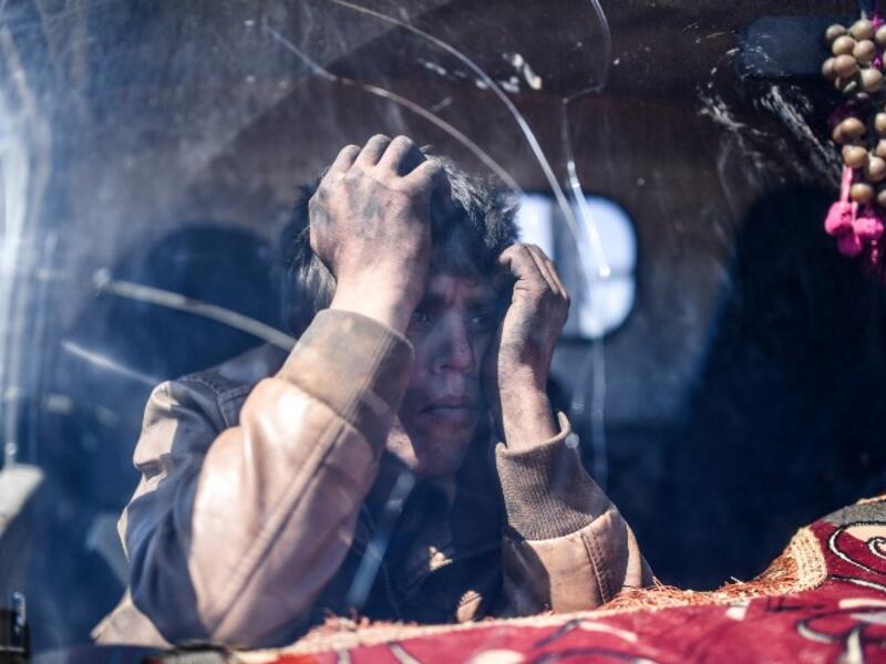 A young boy waits at a check point in the village of Anab ahead of crossing to the Turkish-backed Syrian rebels side on Mar. 17, 2018, as civilians flee the city of Afrin in northern Syria. (BULENT KILIC / AFP)
