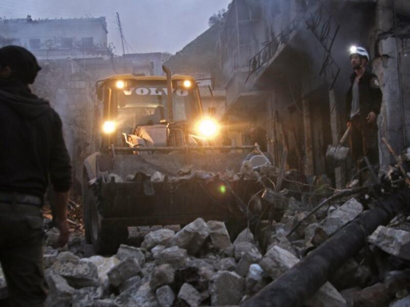 Members of the Syrian civil defence use a bulldozer to clear rubble as they search for survivors in the aftermath of an air strike in the rebel-held town of Harem in the northwestern Idlib province on Mar. 22, 2018. 
(Aaref WATAD / AFP)