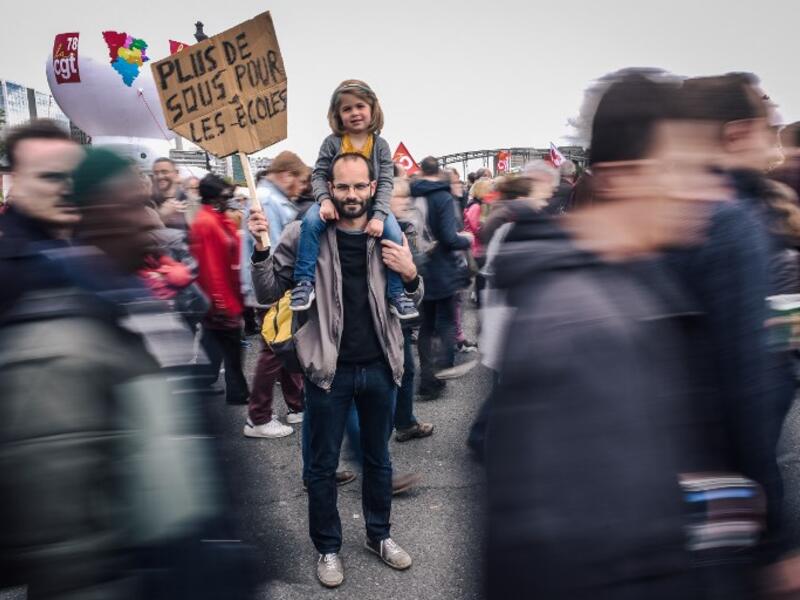 Pierre Gilbert, a 37 year old sociology university teacher, poses with his daughter during the annual May Day workers' rally in Paris on May 1, 2018 / AFP
