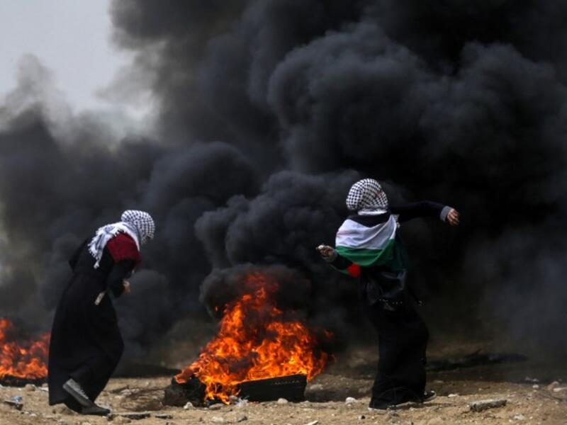 Female Palestinian protesters hurl stones towards Israeli forces during clashes along the border with the Gaza strip east of Gaza City on May 4, 2018, on the sixth straight Friday of mass demonstrations calling for the right to return to their historic homelands. (MAHMUD HAMS / AFP)