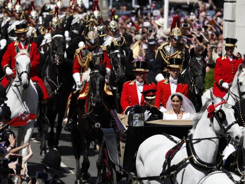 Britain's Prince Harry, Duke of Sussex and his wife Meghan, Duchess of Sussex travel in the Ascot Landau Carriage during their carriage procession on the High Street in Windsor, on May 19, 2018 after their wedding ceremony.
Adrian DENNIS/ AFP