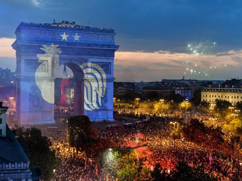 This picture taken from the terrace of the Publicis drugstore on July 15, 2018 shows a projection of the French national football team logo with two stars above on the Paris' landmark Arc de Triomphe 
GERARD JULIEN / AFP