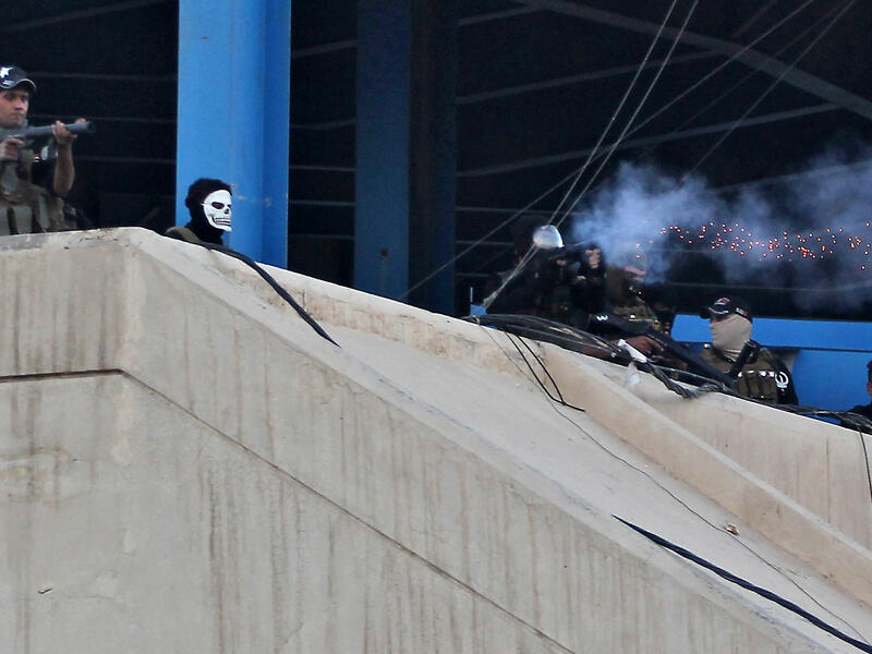 Iraqi security forces fire tear gas toward protesters during a demonstration against unemployment and a lack of basic services in the capital Baghdad's Tahrir Square on July 20, 2018. (AFP/ Ahmad Al Rubaye)
