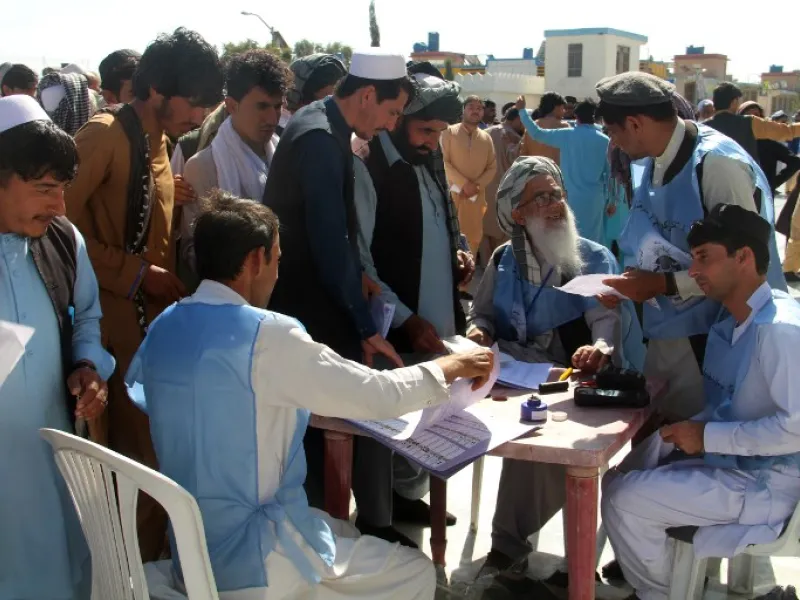 Afghan Independent Election Commission (IEC) officials prepare ballot papers for voters at a polling centre for the country's legislative election in Khost Province on October 20, 2018.
FARID ZAHIR / AFP