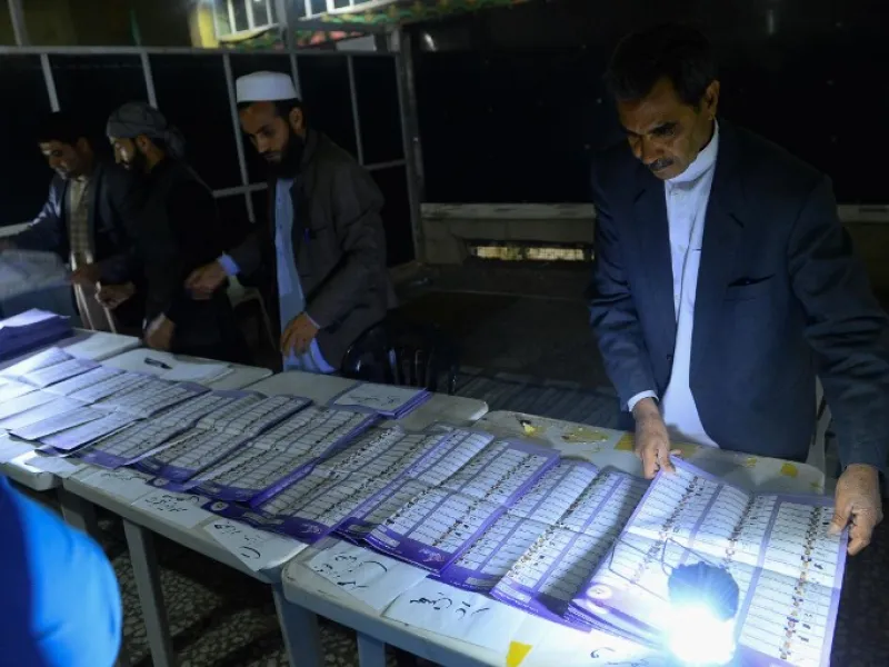 In this photo taken on October 20, 2018, Afghan Independent Election Commission (IEC) officials count ballot papers at a polling centre for the country's legislative election in Herat province. 
HOSHANG HASHIMI / AFP