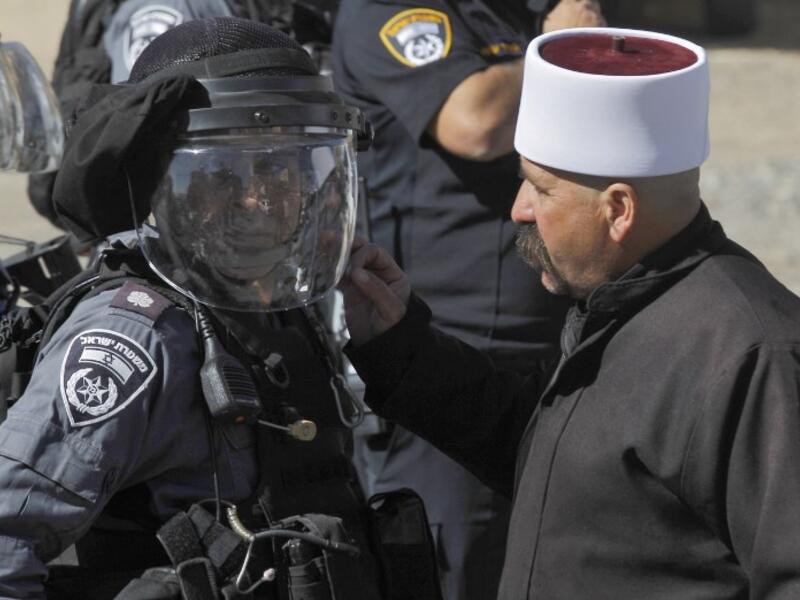 A Druze man speaks to a member of the Israeli security forces during a protest by members of the Druze community against municipal elections. (JALAA MAREY / AFP)