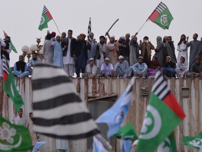 Pakistani supporters of the Ahle Sunnat Wal Jamaat (ASWJ) stand on a container set up to block a street during a protest rally following the Supreme Court's decision to acquit Christian woman Asia Bibi of blasphemy. (AAMIR QURESHI / AFP)