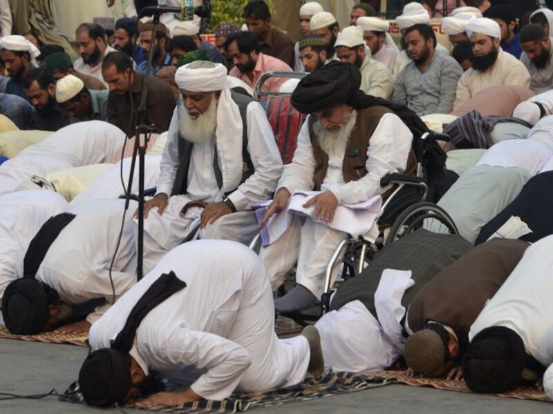 Khadim Hussain Rizvi (centre R), head of the Tehreek-e-Labaik Pakistan (TLP), a hardline religious political party, offers Friday prayers along with supporters during a protest rally in Pakistan. (ARIF ALI / AFP)