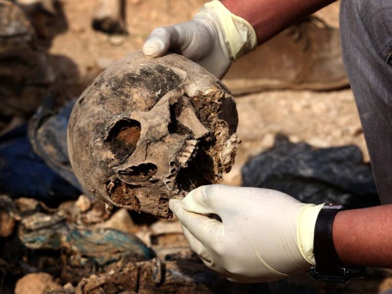 Members of the Yazidi minority search for clues, that might lead them to missing relatives in the remains of people killed by the Islamic State (IS) jihadist group. (Safin HAMED / AFP)