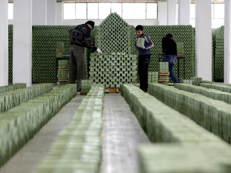 Syrian workers arrange olive soap bars in a factory on the outskirts of Aleppo 
LOUAI BESHARA / AFP