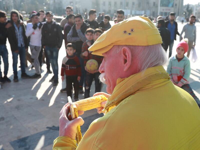 Abu Zakkour, Aleppo's so-called 'yellow man' eats a cob of corn in the northern Syrian city on February 11, 2019. Dressed in yellow from head-to-toe, Abu Zakkour is hailed as part of the "heritage" of the northern Syrian city of Aleppo, along with its medieval citadel and its ancient covered markets. 
LOUAI BESHARA / AFP