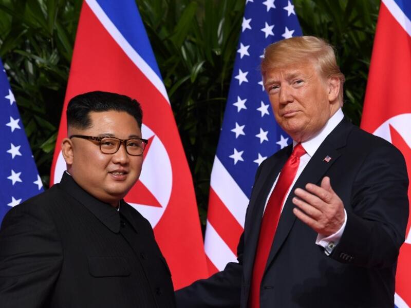 This file photo taken on June 12, 2018 shows US President Donald Trump (R) gesturing as he meets with North Korea's leader Kim Jong Un (L) at the start of their historic US-North Korea summit, at the Capella Hotel on Sentosa island in Singapore. 
SAUL LOEB / AFP