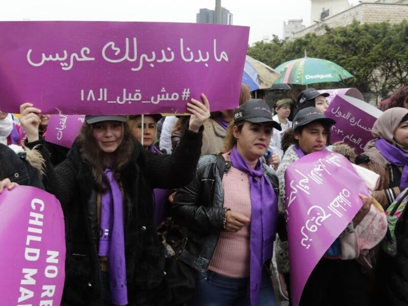 A Lebanese women hold a placards as they participate in a march against marriage before the age of 18, in the capital Beirut on March 2, 2019. The placard in Arabic reads " We do not want to find a groom for you, not before 18". 
ANWAR AMRO / AFP