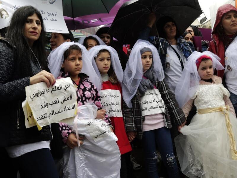 Young Lebanese girls deiguised as brides hold placards as they participate in a march against marriage before the age of 18, in the capital Beirut on March 2, 2019. 
ANWAR AMRO / AFP