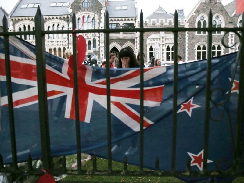 A woman reacts as as she pays her respects in front of floral tributes for victims of the March 15 mosque attacks, in Christchurch 
DAVID MOIR / AFP