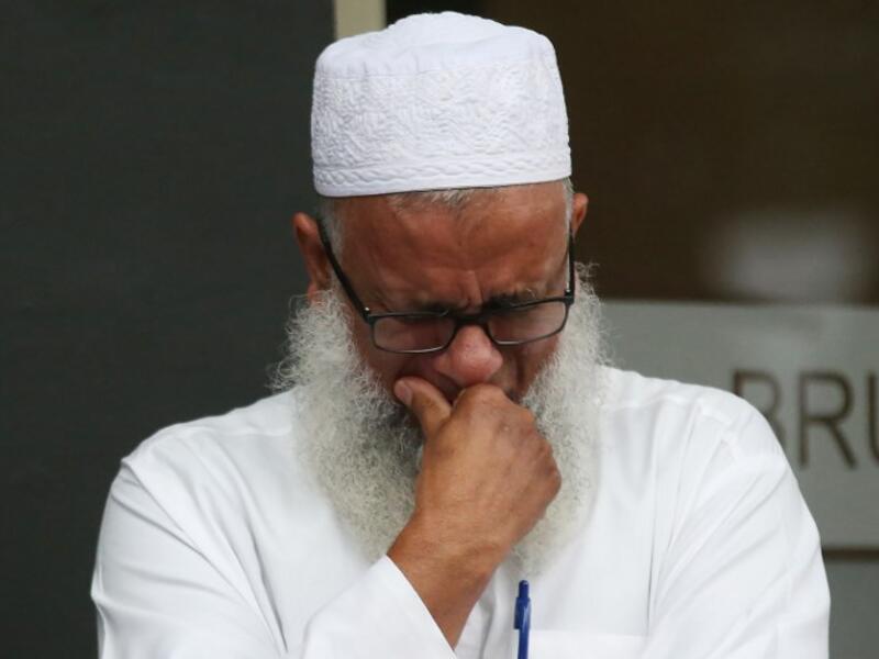A man reacts as people arrive to pay their respects in front of floral tributes for victims of the March 15 mosque attacks, in Christchurch 
DAVID MOIR / AFP