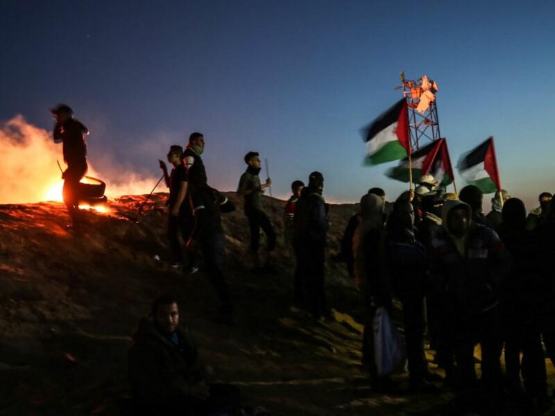 Palestinian protesters take part in a night demonstration near the fence along the border with Israel, in Rafah 
SAID KHATIB / AFP