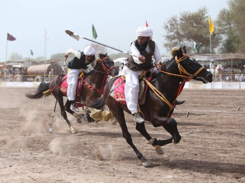 This photograph taken on March 27, 2019, shows Pakistani horse riders with lances used to pick up pegs during an attempt for a Guinness World Record for tent pegging in Khanewal district in Punjab province. 
SS MIRZA / AFP