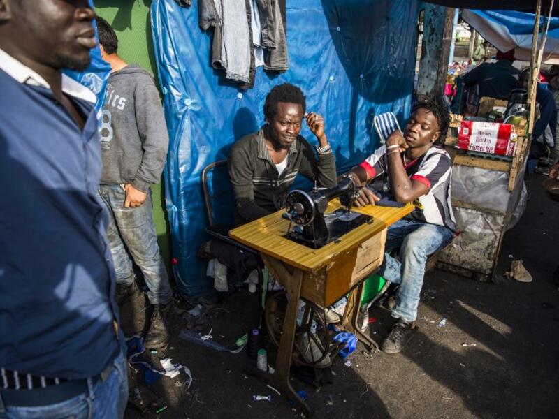 Sub-Saharan migrants sit by a sewing machine at the Oulad Ziane migrant camp in Casablanca on March 27, 2019. 
FADEL SENNA / AFP