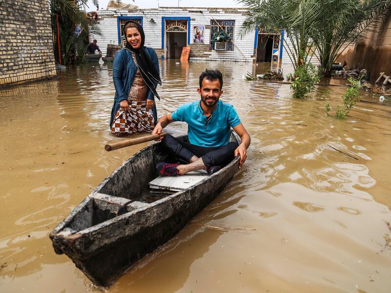 An Iranian man sits in a boat at his flooded garden in a village around the city of Ahvaz, in Iran's Khuzestan province. 
Mehdi PEDRAMKHOO / TASNIM NEWS / AFP