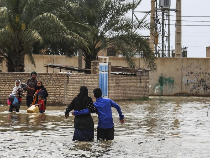 An Iranian family walks through a flooded street in a village around the city of Ahvaz, in Iran's Khuzestan province
Mehdi Pedramkhoo / TASNIM NEWS / AFP