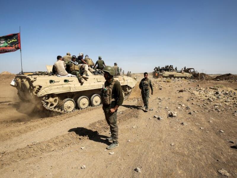 Fighters of the Hashed al-Shaabi (Popular Mobilization) paramilitaries are seen riding on infantry-fighting vehicles during the advance towards villages between the northern Iraqi cities of Hawija and Kirkuk on October 6, 2017
AHMAD AL-RUBAYE / AFP