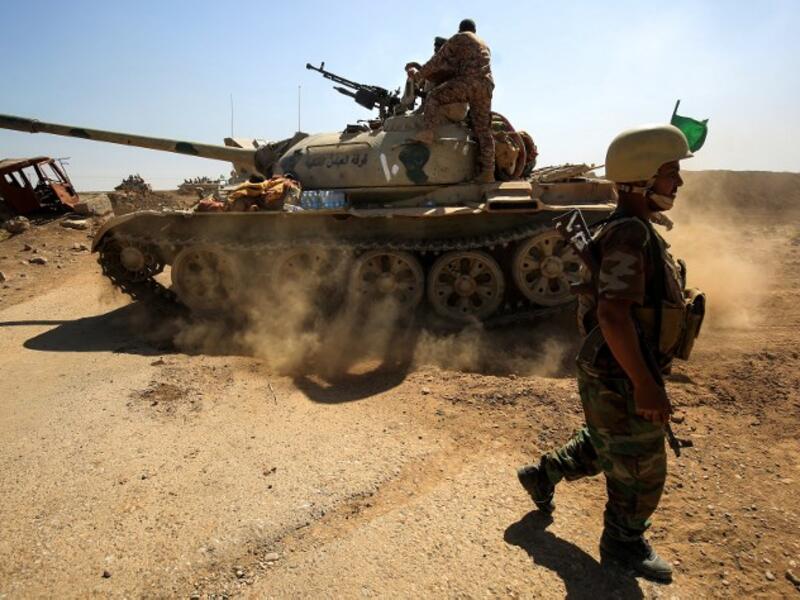 A picture taken on October 6, 2017 shows a tank belonging to the Furqat al-Abbas Brigade of the Hashed al-Shaabi (Popular Mobilisation) paramilitaries advancing towards villages between the northern Iraqi cities of Hawija and Kirkuk
AHMAD AL-RUBAYE / AFP