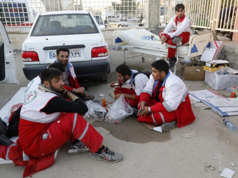 Iranian Red Crescent paramedics eat and rest during a break from tending to quake victims and survivors.

(ATTA KENARE / AFP)
