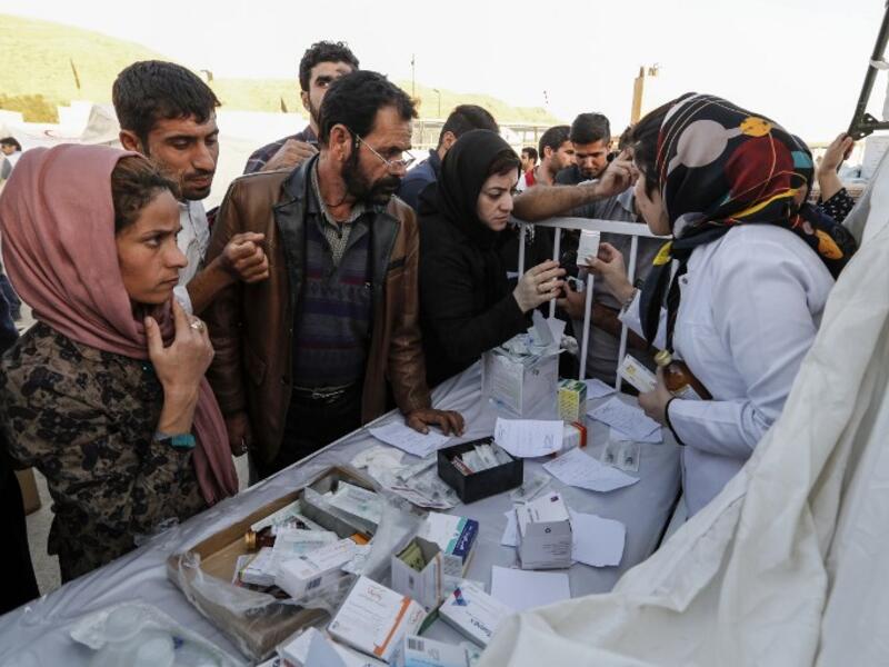 Iranian quake victims and survivors arrive to receive medical supplies at a field hospital in the town of Sarpol-e Zahab.

(ATTA KENARE / AFP)