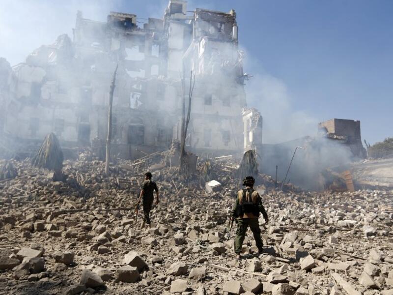 Huthi rebel fighters inspect the damage after a reported air strike carried out by the Saudi-led coalition targeted the presidential palace in the Yemeni capital Sanaa on Dec. 5, 2017 (Mohammed Huwais/AFP)