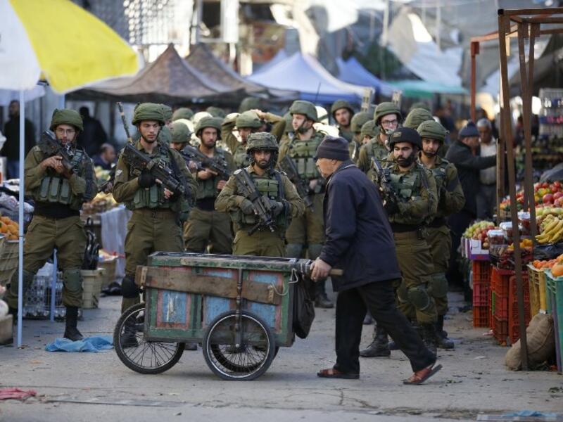 Israeli forces walk down a street during clashes with Palestinian demonstrators in Hebron in the Israeli-occupied West Bank on Dec. 9, 2017, following the US president's controversial recognition of Jerusalem as Israel's capital. 
(HAZEM BADER / AFP)