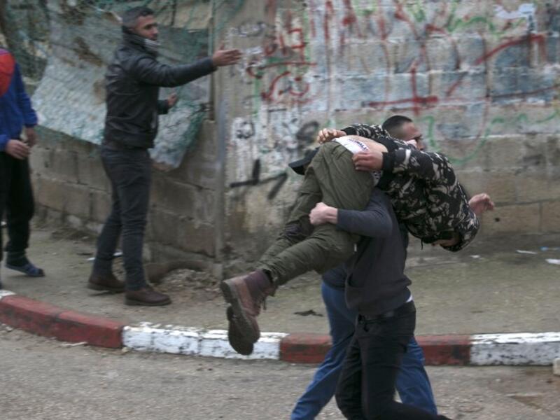 Palestinian youths evacuate a wounded comrade during clashes with Israeli forces in Jenin, in the north of the occupied West Bank, on Jan. 18, 2018 (JAAFAR ASHTIYEH / AFP)