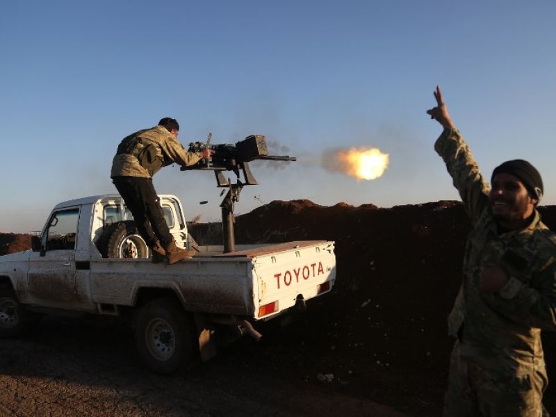 Turkish-backed fighters from the Free Syrian Army stand in the Tal Malid area, north of Aleppo, as they fire towards Kurdish People's Protection Units (YPG) positions in the village of Um al-Hosh, in the area of Afrin, on Jan. 20, 2018 (Nazeer al-Khatib / AFP)