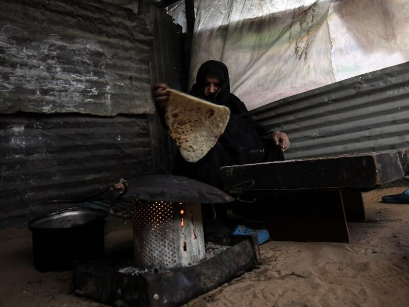 A Palestinian mother bakes bread in the Rafah refugee camp in the southern Gaza Strip on Jan. 24, 2018 (SAID KHATIB / AFP)