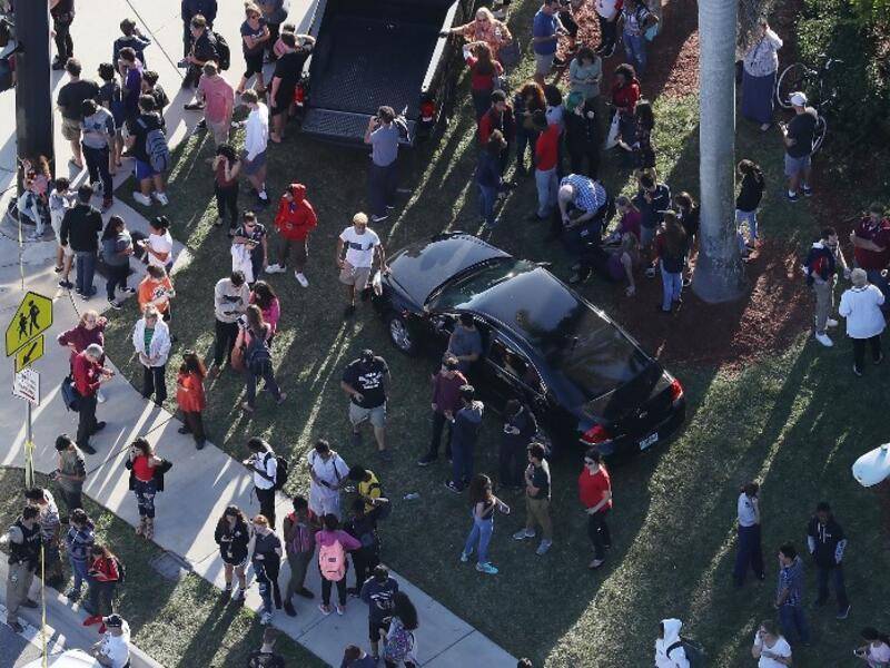People wait for loved ones as they are brought out of the Marjory Stoneman Douglas High School after a shooting at the school that reportedly killed and injured multiple people on Feb. 14, 2018 in Parkland, Florida. Numerous law enforcement officials continue to investigate the scene.
(JOE RAEDLE / GETTY IMAGES NORTH AMERICA / AFP)
