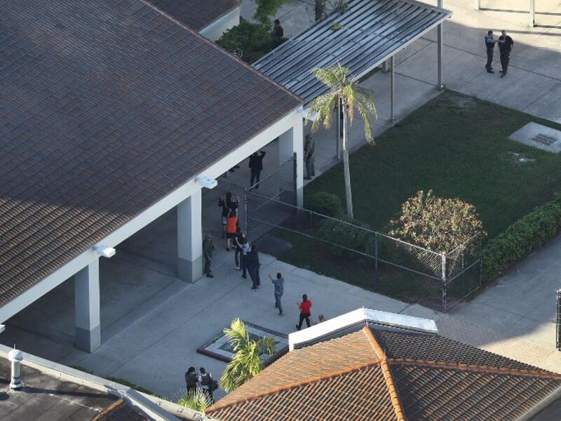 People are brought out of the Marjory Stoneman Douglas High School after a shooting at the school that reportedly killed and injured multiple people on Feb. 14, 2018 in Parkland, Florida. Numerous law enforcement officials continue to investigate the scene. 
(Joe Raedle/Getty Images/AFP)