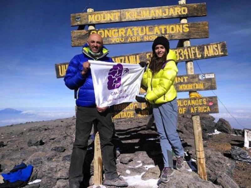 Mountaineers Mostafa Salameh and Farah Raed Abu Baker raise the Jordan Alzheimer’s Association banner on top of Mount Kilimanjaro in April 2017 (Photo courtesy of the JAA)
