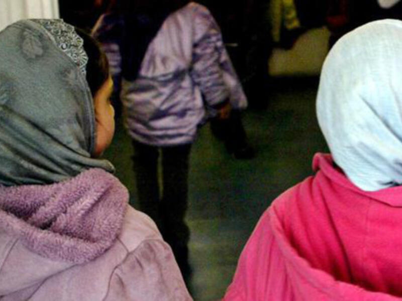Investigation into online abuse targeting the head teacher of an East London where girls younger than the age of eight were banned from wearing the hijab (AFP)