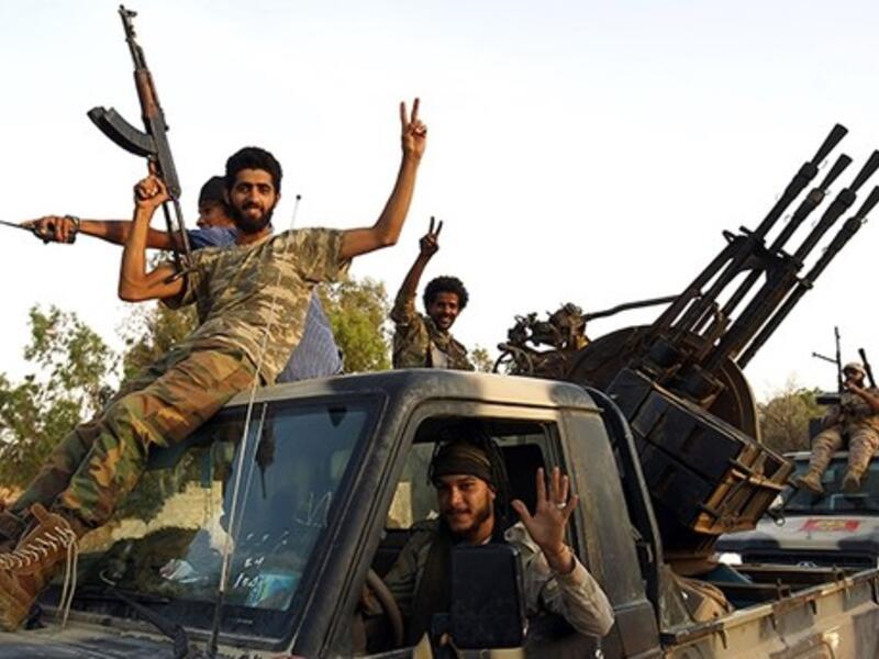 Members of the Salah Bou-Haliqa brigade celebrate as they arrive in the eastern city of Benghazi. (AFP Photo)